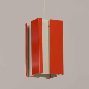 Può includere: Un lampadario a forma quadrata con strisce rosse e bianche.