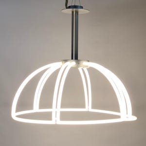 Può includere: Un lampadario moderno a forma di cupola bianca con una struttura in metallo argentato e un'asta di sospensione in metallo argentato.