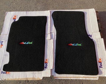 May include: Two black car floor mats with the word "del Sol" embroidered in colorful letters.