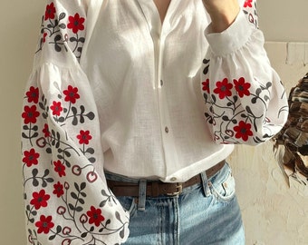 Witte linnen blouse met traditioneel donkergrijs - rood patroon. Oekraïens cultureel borduurwerk. Folk geborduurd kledingstuk. Natuurlijke prachtige stof