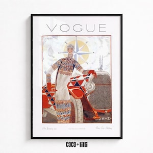 Op de afbeelding: Een ingelijste print van een Vogue-tijdschriftomslag uit januari 1925 met een persoon in een trui en rok met patroon naast een rood-witte auto met een kompasroos op de achtergrond. De tekst VOGUE staat in het zwart bovenaan gedrukt.