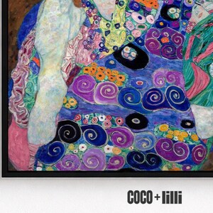 May include: A framed art print featuring a vibrant, abstract composition with swirling patterns in shades of blue, purple, pink, and green, accented by small yellow and orange circular motifs. The text COCO + lilli appears in black at the bottom.