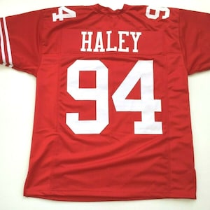 May include: Red football jersey with white numbers and stripes. The jersey has the name "HALEY" and the number "94" on the back.