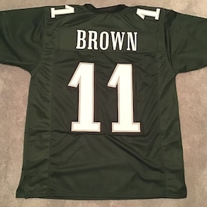 May include: Green football jersey with the number "11" and the name "BROWN" on the back.