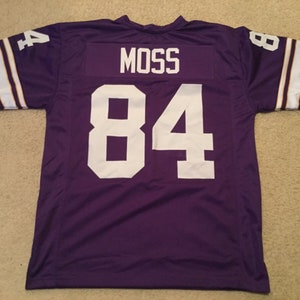 May include: Purple football jersey with white lettering. The jersey has the name "Moss" and the number "84" on the back.