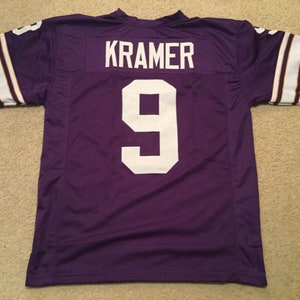 May include: Purple football jersey with white lettering. The name "KRAMER" and the number "9" are on the back of the jersey.