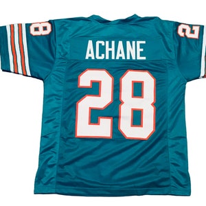 May include: Teal football jersey with white and orange accents. The jersey features the name "ACHANE" above the number "28" in white with an orange outline. The sleeves have white stripes with orange accents and the number "8" on the shoulder.