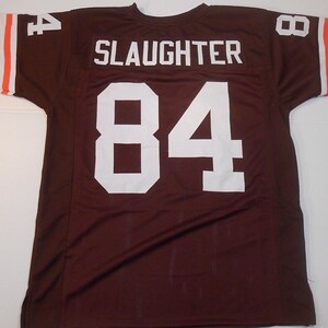May include: Brown football jersey with white lettering. The name "SLAUGHTER" and the number "84" are on the back of the jersey.