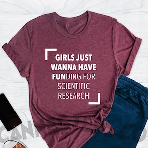 May include: Heather maroon t-shirt with the text "Girls just wanna have funding for scientific research" printed in white.