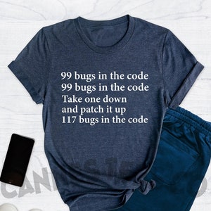 May include: A heather navy blue t-shirt with the text "99 bugs in the code 99 bugs in the code Take one down and patch it up 117 bugs in the code" printed in white.