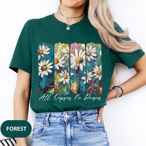 May include: A green t-shirt with a colorful abstract daisy print and the text "All Oppsies No Daisies".