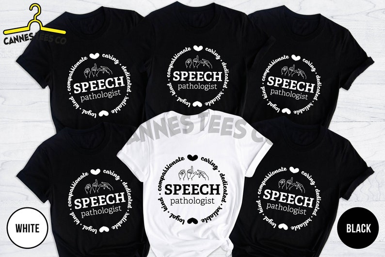 Op de afbeelding: Vijf T-shirts in zwart en wit met een cirkelvormig ontwerp met de tekst "SPEECH pathologist" en een handgebaar voor de letter "S". De tekst "compassionate, caring, dedicated, reliable, loyal, kind" omringt de cirkel.