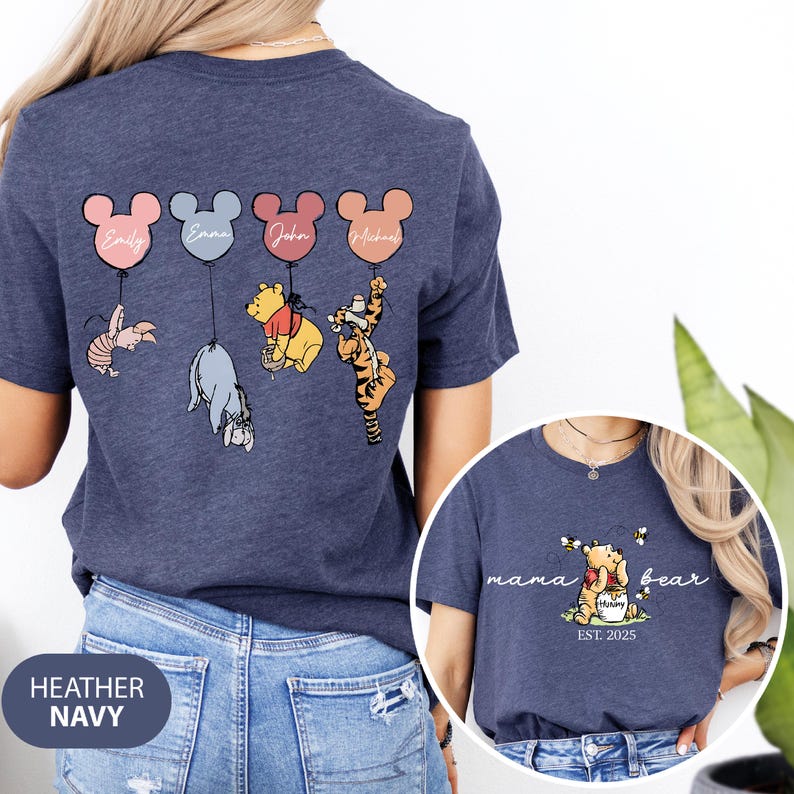 May include: A heather navy blue t-shirt with a Winnie the Pooh and friends design. The shirt features four characters holding balloons with names on them. The back of the shirt says "mama bear est. 2025".