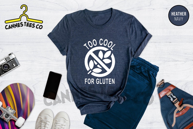 May include: A heather navy blue t-shirt with a white graphic that says "Too Cool For Gluten" with a crossed-out wheat symbol.