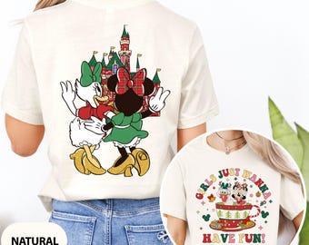 May include: Cream-colored t-shirt featuring Daisy Duck and Minnie Mouse with a castle graphic on the back. The shirt also has a circular graphic with the text "GIRLS JUST WANNA HAVE FUN!" and images of Daisy and Minnie in a teacup.
