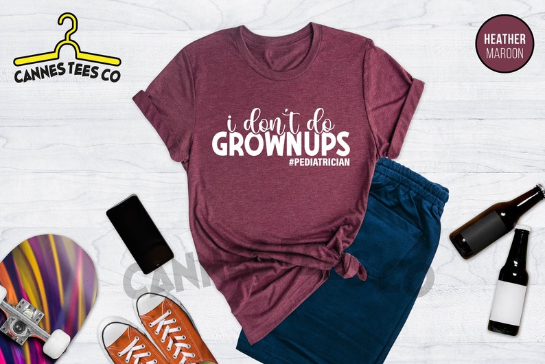 May include: Heather maroon t-shirt with the text "i don't do grown ups #pediatrician".