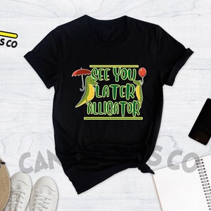 May include: Black t-shirt with a green alligator graphic and the text "See you later alligator".