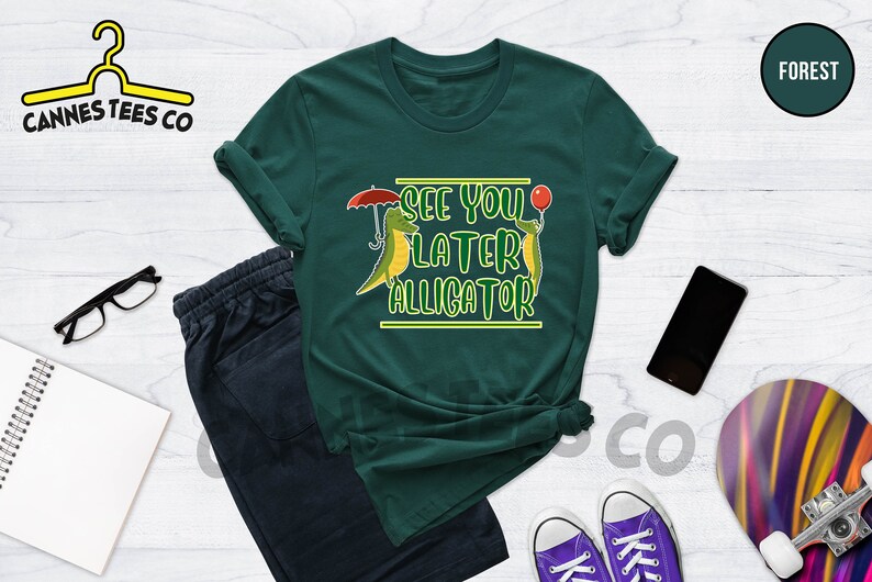 May include: A green t-shirt with a graphic of two cartoon alligators. The text on the shirt reads "See you later alligator".