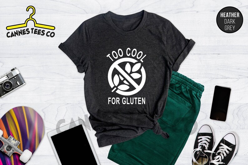 May include: A heather dark grey t-shirt with a white graphic of a crossed-out wheat stalk and the text "Too Cool For Gluten".