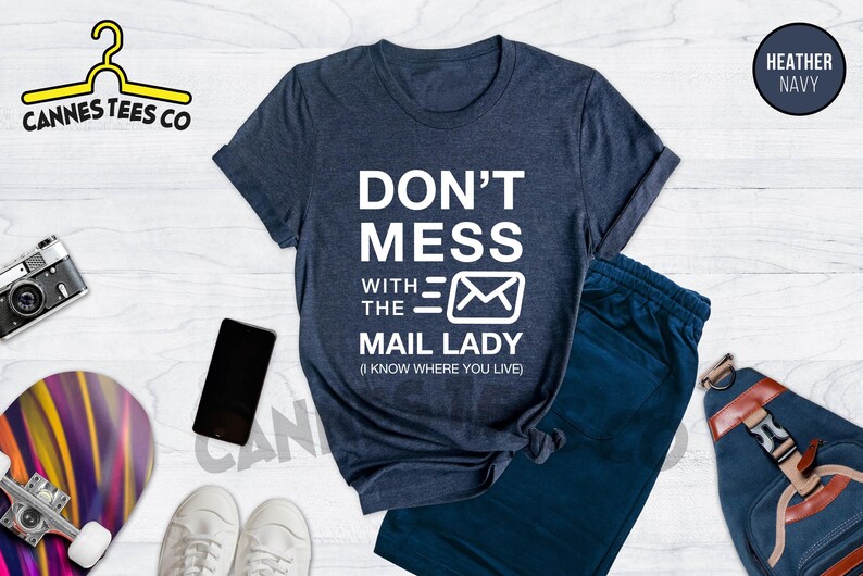 May include: A heather navy blue t-shirt with white text that reads "Don't Mess With The Mail Lady (I Know Where You Live)".