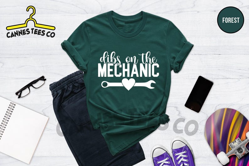 Może przedstawiać: Zielony T-shirt z białym napisem "dibs on the mechanic" i kluczem z sercem w środku.