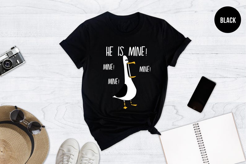 May include: Black t-shirt with a white graphic of a seagull with the text "He is mine! Mine! Mine! Mine!"