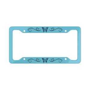 May include: A light blue license plate frame with a butterfly design. The frame has a rectangular shape with rounded corners. The butterfly is blue and purple, and the frame has decorative swirls.