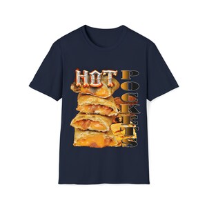 以下が含まれることがあります： 紺色のTシャツに、ホットポケットの山と「HOT POCKETS」という文字が金色とオレンジ色のフォントで描かれています。