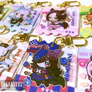 以下が含まれることがあります： アニメスタイルのキャラクターが特徴のアクリルキーホルダーのコレクション。各キーホルダーは、金色の留め金と、ユニークなキャラクターデザインの長方形の形をしています。キーホルダーはカラフルで、さまざまな衣装のキャラクターが含まれています。