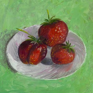 Le fragole rosse su un piatto bianco sono ancora vive