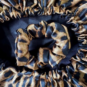 Uma peça única e exclusiva, confeccionada com cuidado e atenção aos detalhes. O contraste entre o cetim preto atemporal e a estampa de leopardo moderna cria um acessório versátil e sofisticado.