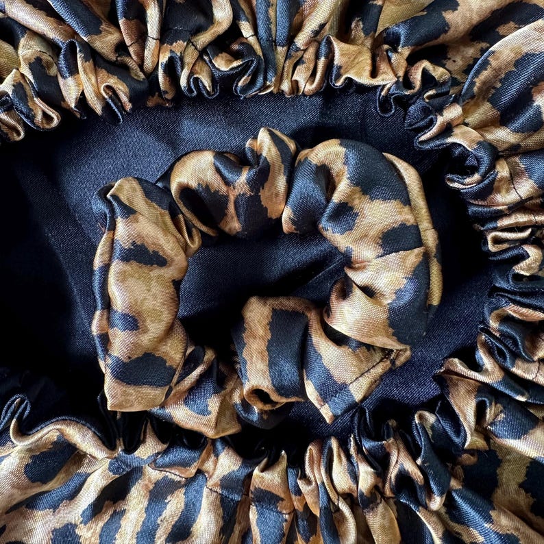 Uma peça única e exclusiva, confeccionada com cuidado e atenção aos detalhes. O contraste entre o cetim preto atemporal e a estampa de leopardo moderna cria um acessório versátil e sofisticado.