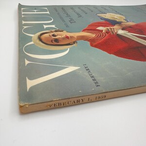 May include: A vintage Vogue magazine cover from February 1, 1959, featuring a woman in a red dress and a white hat. The cover text reads "The Fashions: American Women in the World of High Fashion" and "February 1, 1959".