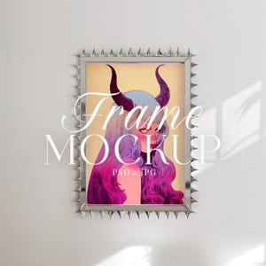 Puede incluir: Un marco plateado con púas alrededor del borde, que presenta una ilustración colorida de una mujer con cuernos y cabello morado. El texto "Frame Mockup PSD & JPG" está impreso en la parte inferior de la imagen.