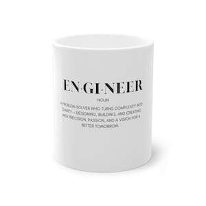 Könnte beinhalten: Weißer Keramikbecher mit dem Wort "ENGINEER" in Schwarz, zusammen mit einer Definition. Die Definition beschreibt einen Ingenieur als Problemlöser, der Komplexität in Klarheit verwandelt.
