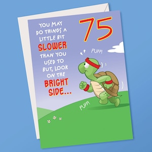 May include: A birthday card with a cartoon turtle running uphill. The card has the number 75 in red and yellow. Text on the card reads "You may do things a little bit slower... but look on the bright side."