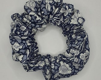 Mini cotton hair scrunchie in navy fabric with white floral / flower pattern.