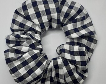 Hair scrunchie in navy and white colour in gingham pattern fabric.