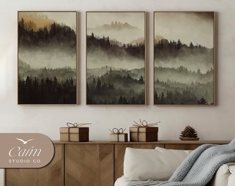 Könnte beinhalten: Drei gerahmte Landschaftsbilder mit einer nebeligen Waldszene in Grün- und Brauntönen. Die Bilder hängen an einer weißen Wand über einem Holzschrank mit drei verpackten Geschenken darauf.