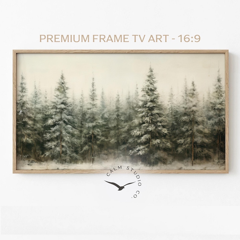 Puede incluir: Una impresi&oacute;n art&iacute;stica enmarcada que presenta una serena escena de bosque con &aacute;rboles de hoja perenne cubiertos de nieve. La obra de arte est&aacute; en un marco de madera rectangular. El texto en la parte superior dice "PREMIUM FRAME TV ART - 16:9". La esquina inferior derecha tiene un logotipo con un p&aacute;jaro y el texto "CALM STUDIO CO."
