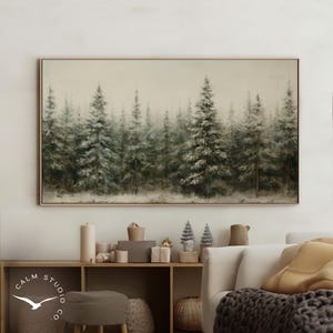 May include: A framed landscape painting depicts a misty forest of evergreen trees. The artwork features a muted color palette of greens, grays, and browns, creating a serene and naturalistic scene. The painting is displayed above a wooden shelf with decorative items.
