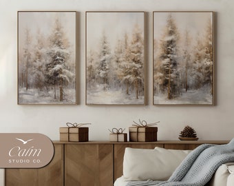 May include: Three framed canvas prints of a winter forest scene with snow-covered trees in shades of brown and white. The prints are hung on a white wall above a wooden cabinet and a white couch with a gray throw blanket.