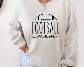 May include: A light beige sweatshirt with a black graphic of a football and the text "FOOTBALL mom".