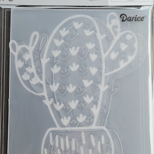 May include: Clear embossing folder featuring a cactus design. The cactus is in a pot, with a detailed outline. The folder is in a clear plastic package with the text "EMBOSSING FOLDER" and the brand name "Darice".