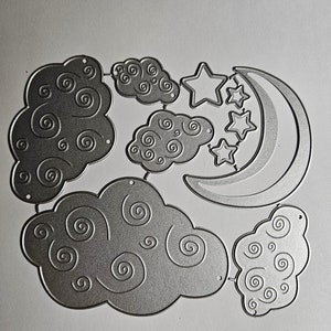 May include: Silver metal die cuts of clouds, stars, and a crescent moon. The clouds have a swirled design. The stars are five-pointed. The moon is a crescent shape. These are likely for scrapbooking or card making.