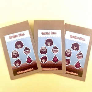May include: Three brown paper packages with sticker sheets. Each sheet has a light blue background with cartoon character stickers. The text "Gacha Lisa" is at the top, and "EllieCupcakesArt" is at the bottom.