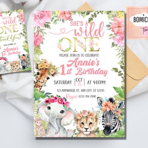 May include: A pink and gold first birthday party invitation with a jungle theme. The invitation features a giraffe, elephant, lion, and zebra with floral headbands. The text reads "She's a wild one" and "Annie's 1st Birthday".