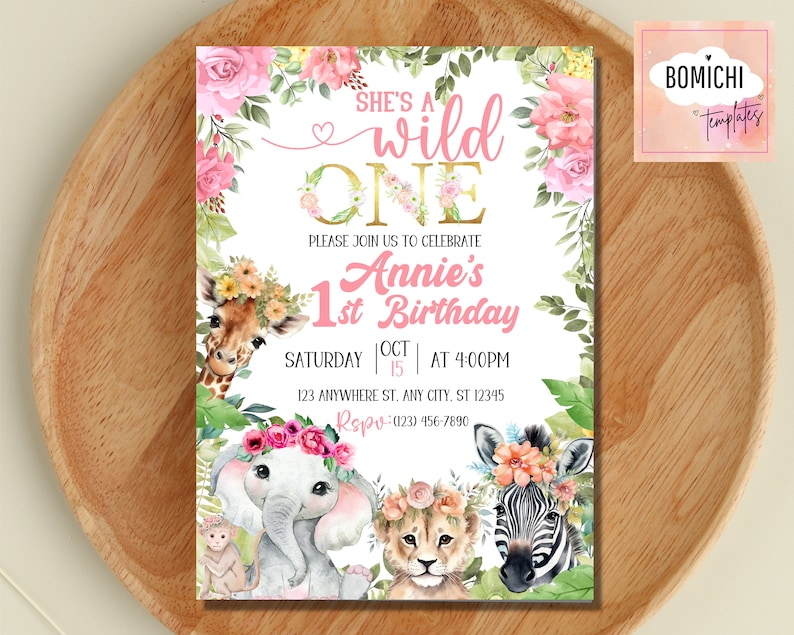 May include: A pink and gold first birthday party invitation with a jungle theme. The invitation features a giraffe, elephant, lion, and zebra with floral headbands. The text on the invitation reads "She's a wild one, Annie's 1st Birthday, Saturday Oct 15 at 4:00pm, 123 Anywhere St. Any City, ST 12345, RSVP (123) 456-7890".