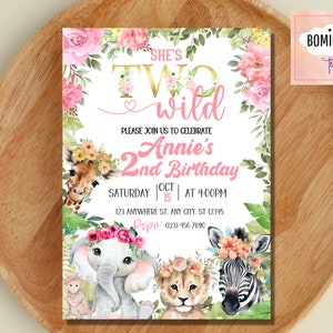 May include: A pink and gold invitation card with a jungle theme. The text reads "She's Two Wild Annie's 2nd Birthday" with a giraffe, elephant, lion, and zebra illustration.
