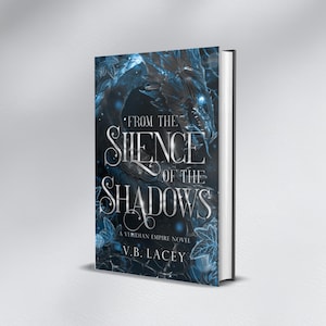 Może przedstawiać: Książka w twardej oprawie zatytułowana "From the Silence of the Shadows" z ciemnoniebieskim i srebrnym wzorem okładki. Okładka zawiera ilustrację smoka i nazwisko autora, V.B. Lacey.